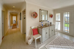 Entrance hallway and hallway to the bedrooms with wooden floors and rugs at Penamont