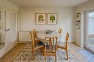 Dining area at Penamont from the kitchen with table and chairs. Internal double doors into the lounge and double door onto the rear paved area