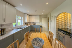 Kitchen area with kitchen table and chairs and large oven and hob and kitchen sink at Penamont