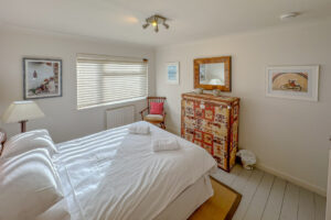 King bedroom at Penamont with chest of drawers, wooden painted floor with window to the front of the house