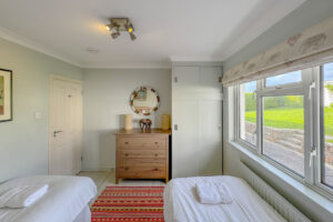 Twin room with built in wardrobe, chest of drawer and window to the rear garden