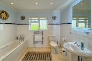 Superking ensuite bathroom at Penamont showing bath with hand held shower, toilet, wash hand basin and heated towel rail