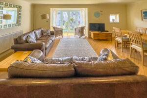 Open plan lounge with TV and dining area with sea views at Apartment 5 Greenwaves