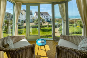Sea views across Trevone Bay with double doors in seating area at Apartment 5 Greenwaves