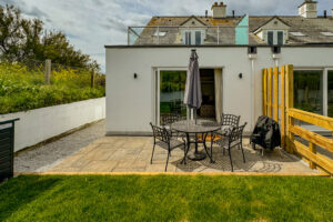 View of patio, outside furniture and rear of the house from the grassed rear garden at Penjerrick