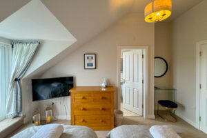 Twin room at Penjerrick with TV and entry to en suite bathroom