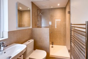 Shower room off the back lobby at Tregarne with shower cubicle and wash basin and toilet