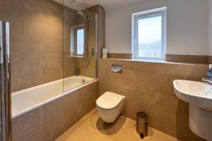 The bathroom off the entrance hall at Tregarne with bath, toilet and wash basin