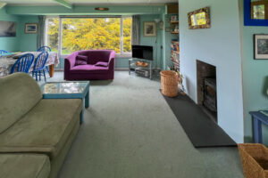 Lounge area with seating, television and wood burner at Thalassa