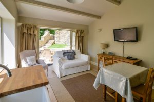 Lounge area with patio doors leading outside at Pensile House Cottage