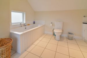 First floor ensuite bathroom at Parc Vean showing bath with hand held shower unit and toilet.