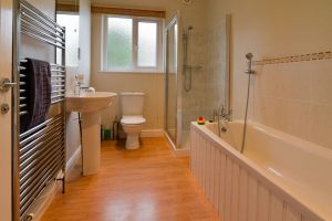 Ground floor bathroom at Parc Vean showing bath with hand held shower, shower cubicle, toilet and wash hand basin