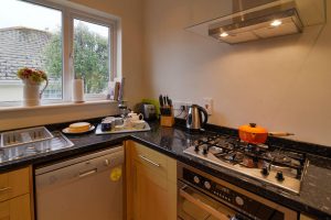 Kitchen area at Parc Vean with hob, oven and overhead extractor