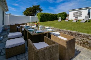 Outside patio area with outside dining furniture and other outside seating with garden and garden room