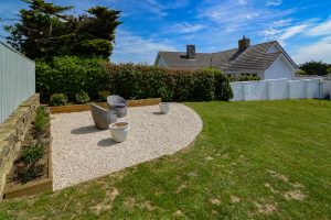 Gravelled seating area with seating in the top corner of the garden