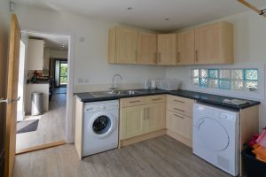 Utility room at Pendoric with washing machine and tumble dryer