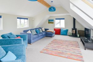 First floor lounge at Pendoric with log burner and TV