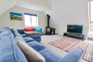First floor larger lounge at Pendoric with log burner and TV