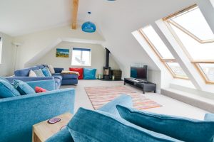 First floor lounge with log burner and TV at Pendoric