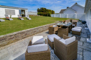 Rear garden at Penamont with patio, outside dining furniture, sun loungers and garden room with small pool table