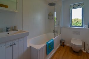 Main family bathroom with bath tub and overhead shower at Ridgegrove