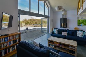 Lounge area with mounted TV and log burner at Ridgegrove