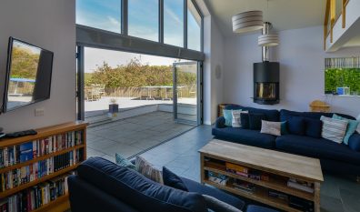 Lounge area with mounted TV and log burner at Ridgegrove