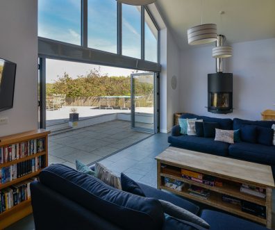 Lounge area with mounted TV and log burner at Ridgegrove