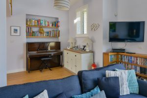 Mounted TV, book cases and piano in corner of lounge area at Ridegrove