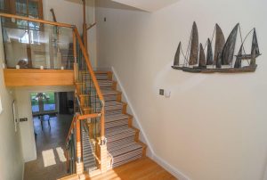 Stairs down to the ground floor garden level, stairs up to first floor living area and top floor twin room from the entrance way at Sailaway