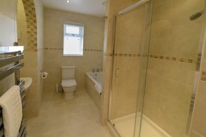 Lower level bathroom with shower cubicle, toilet and sink at Sailaway