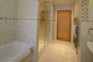 Lower level garden floor bathroom at Sailaway showing shower cubicle, sink, bath and heated towel rail