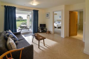 Lower garden level lounge area at Sailaway with patio doors, television and optional sofa bed if beds for 10 needed