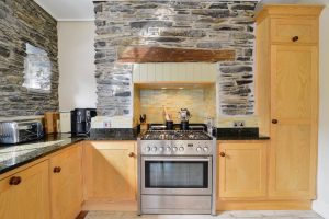 Cooking range in the kitchen with feature stone wall at Santa Marina