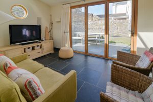 Doors to rear yard from small lounge area and outside table and benches at Santa Marina