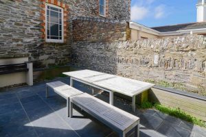 Rear yard with table and benches at Santa Marina