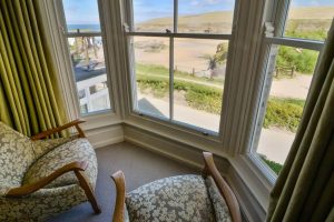 Seating in the bay window of the master bedroom at Santa Marina and view across the beach to the ocean