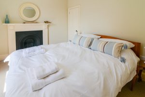 First floor bedroom at rear of Santa Marina with king bed and feature fireplace