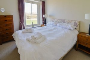 First floor bedroom at front of Santa Marina with king bed and window view to beach