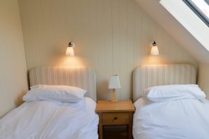 Twin bedroom on the second floor with bedside table at Santa Marina