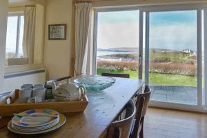 Dining area at South Corner with large sliding doors onto the patio area and view over Treyarnon Bay