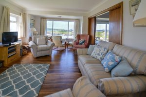 Lounge area at South Corner with ample seating and large window views over Treyarnon Bay