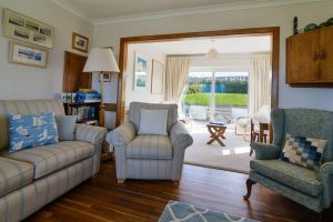 Lounge area at South Corner with large doors to a small patio area on the landward side of the house.