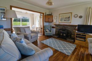 Lounge area at South Corner with ample seating woodburner and tv.