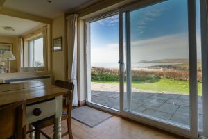 Sliding door with views over the rear patio and garden toward Trevose Head from the dining area at South Corner