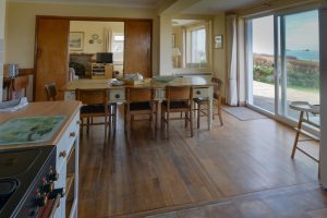 Open plan dining and kitchen area with sliding doors to the patio and also sliding doors to the lounge at South Corner