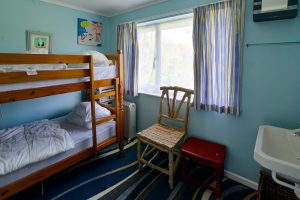 Bunk room at Thalassa with large window to garden and wash hand basin