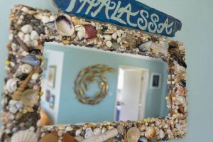 Picture of mirror with shell frame and house name at Thalassa
