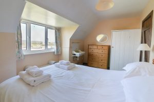 First floor king bedroom at The Buck with wash basin and views over the beach and ocean