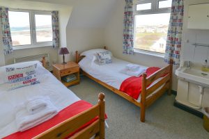 The second of the twin bedrooms on the first floor at The Buck with wash basin and views to front and side of the house
